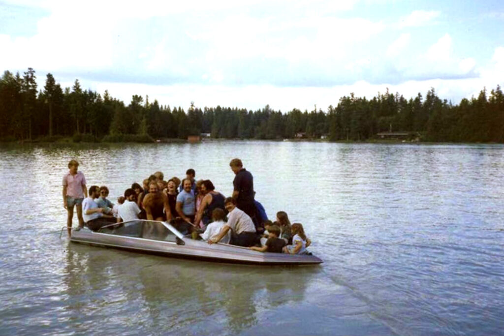 speed boat with a group of people some riding on the bow